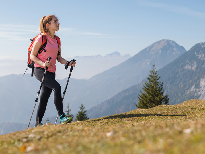 Frau wandert bergauf auf einer Wiese auf dem Weg raus aus dem Burnout zu mehr Kraft und Veränderung durch Coaching